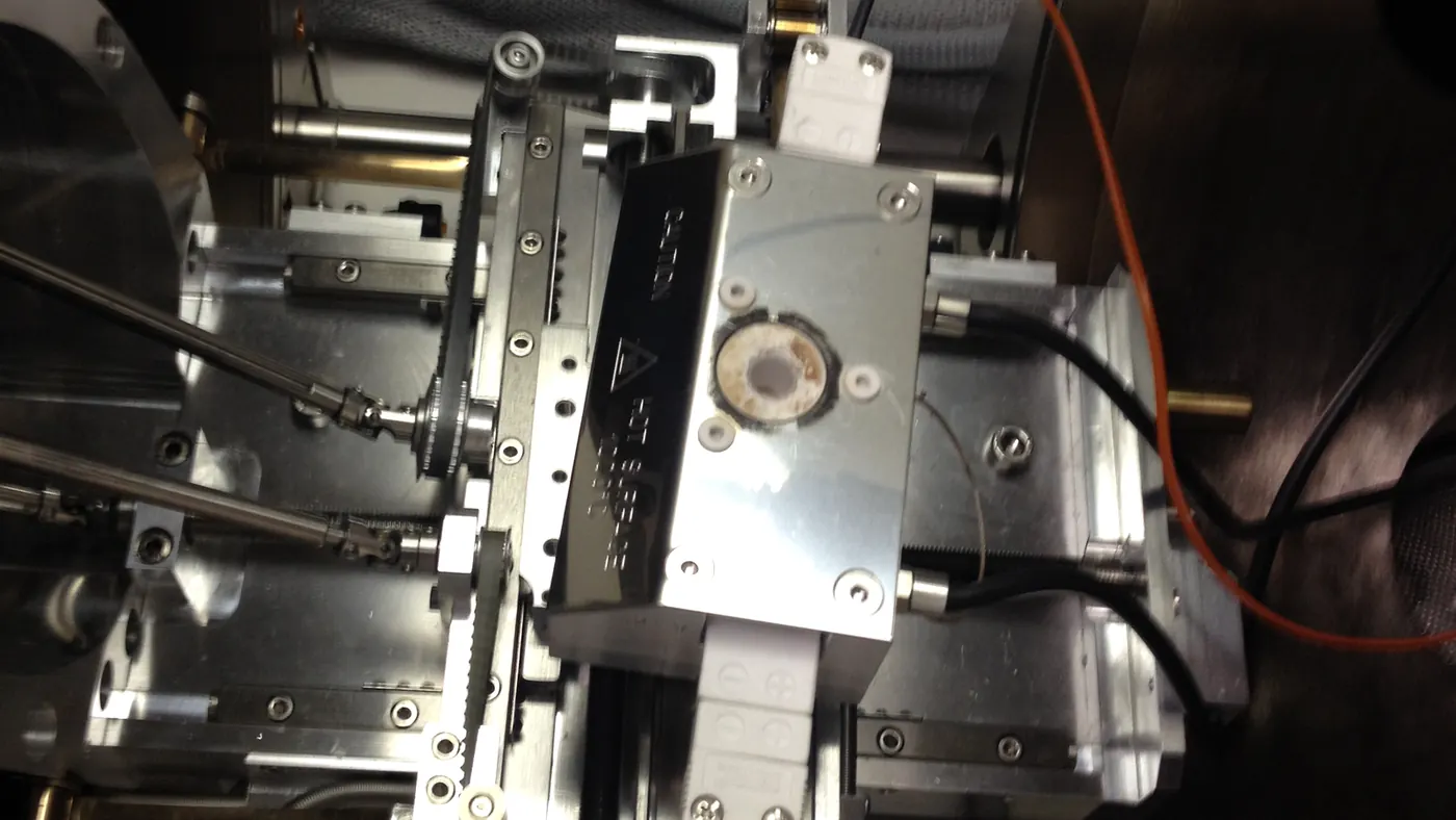 Real SEM hot-stage assembly installed inside an SEM chamber with heater surface and electrical connections.